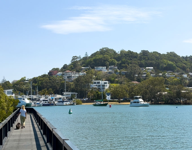 Woman and dog on boardwalk at Terranora Creek