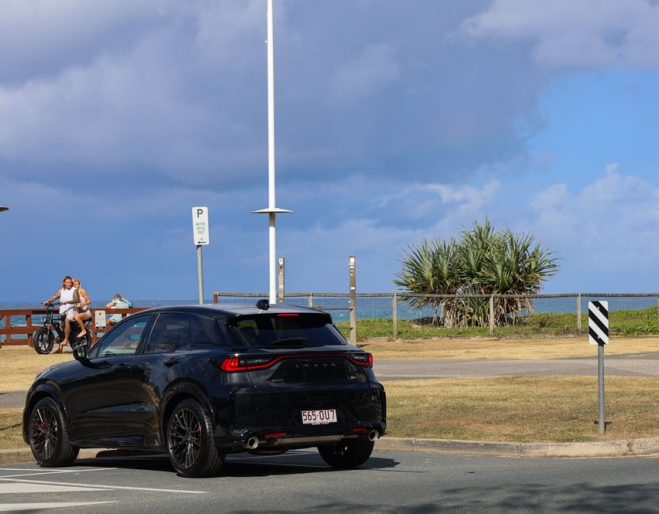 Black Lexus LBX parked in front of a beach 