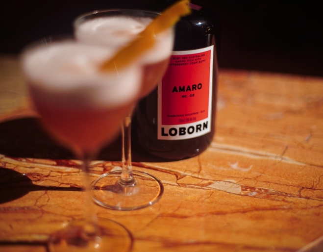 Bottle of amaro and two glasses on a wooden table at Loborn Tamborine Mountain 