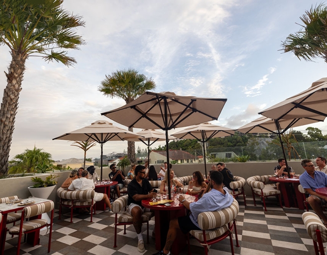 People sitting on al fresco terrace at Sueño Rooftop Nobby Beach
