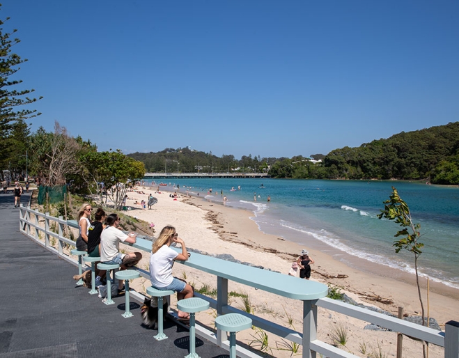 People seated on stools on Tallebudgera Boardwalk