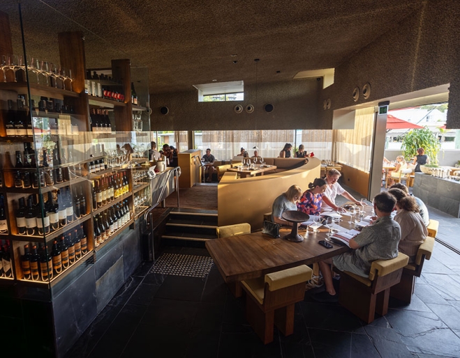 Diners inside Norte next to wine cabinet