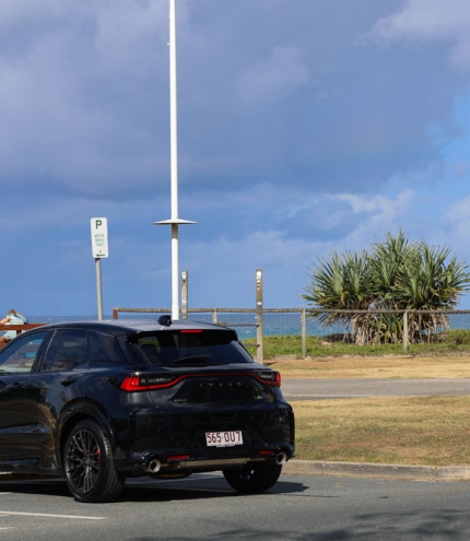 Black Lexus LBX parked in front of a beach 
