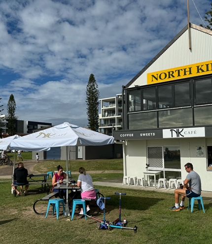 People seated on grass at NK Cafe Kirra