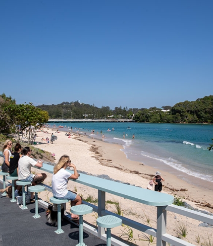 People seated on stools on Tallebudgera Boardwalk