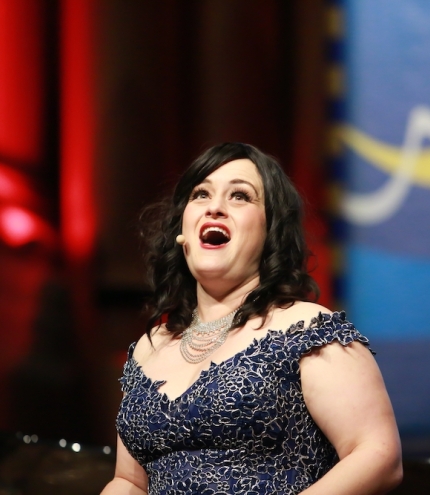 Singer Gabrielle Jack singing in front of red curtain Songs & Soiree