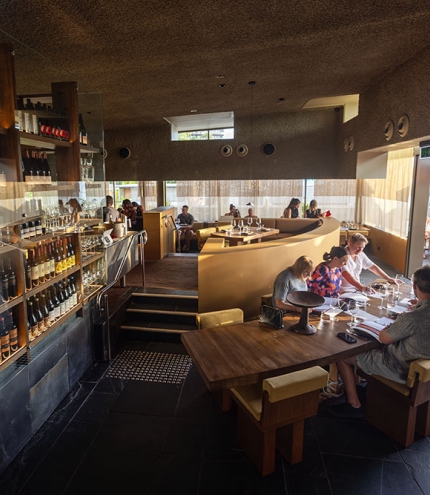 Diners inside Norte next to wine cabinet