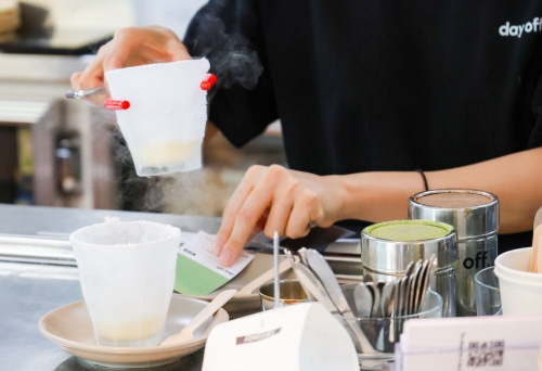 Girl making coffees behind a counter, Day Off Southport 