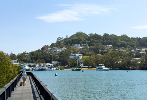 Woman and dog on boardwalk at Terranora Creek