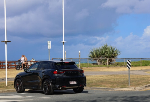 Black Lexus LBX parked in front of a beach 