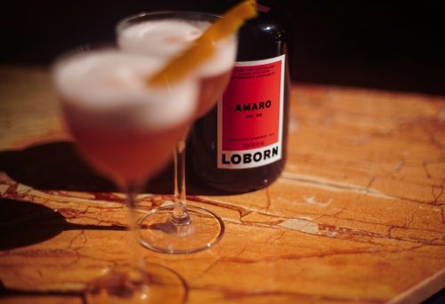 Bottle of amaro and two glasses on a wooden table at Loborn Tamborine Mountain 