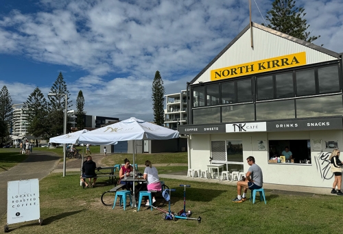 People seated on grass at NK Cafe Kirra