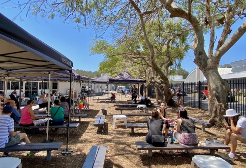 People outside on tables at Palm Beach Farmers' Market, Palm Beach