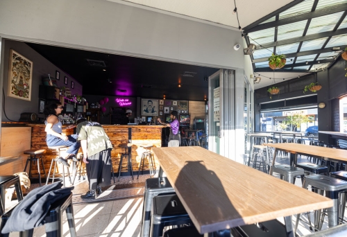 A balcony of a bar with bench-style tables, Walk-ins Welcome Southport