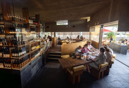 Diners inside Norte next to wine cabinet