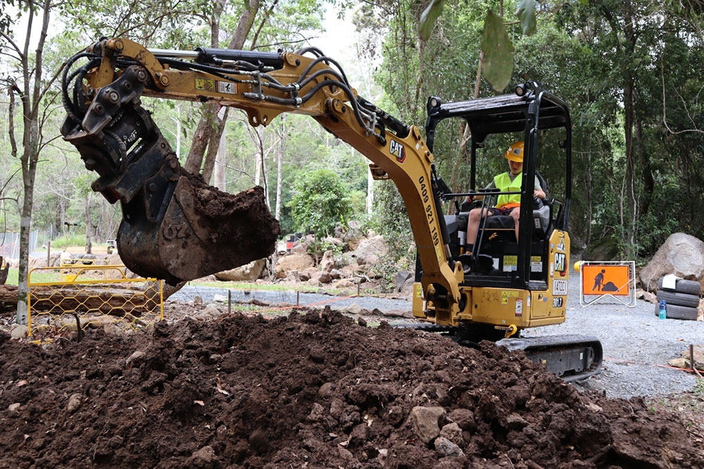Child digging sand in a mini excavator at Dig IT Tamborine Mountain