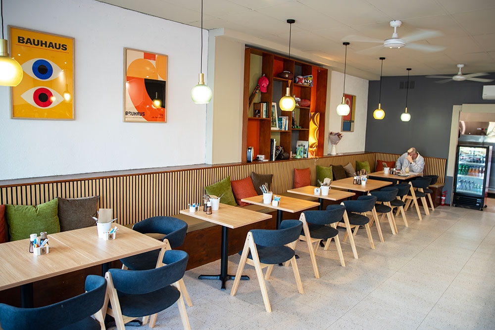 Tables and chairs lined up against wall at Bantr Cafe Palm Beach