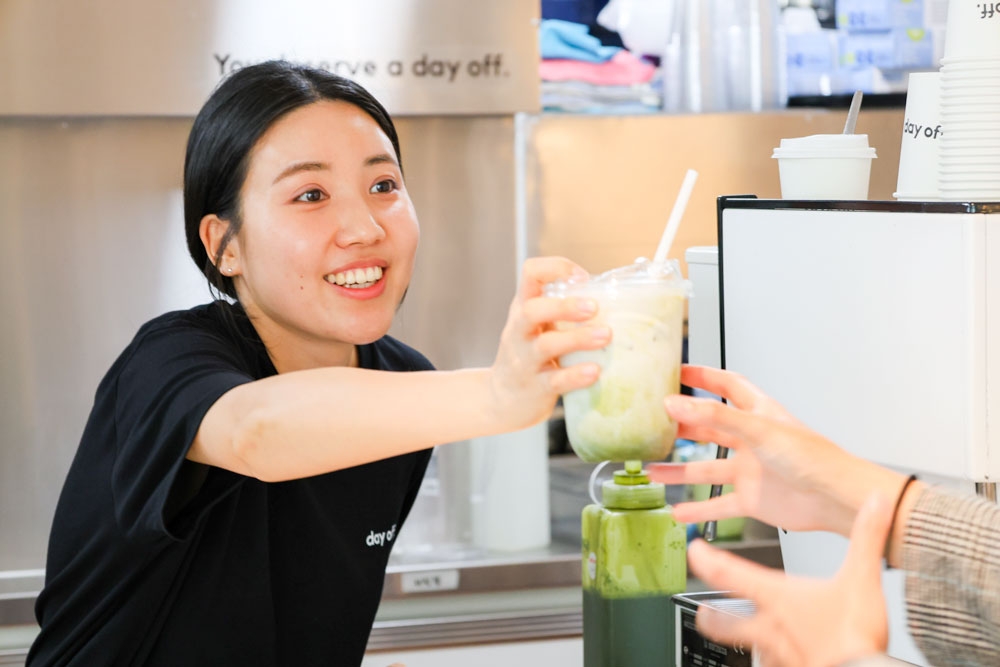 Girl handing over drink to customer, Day Off Southport 