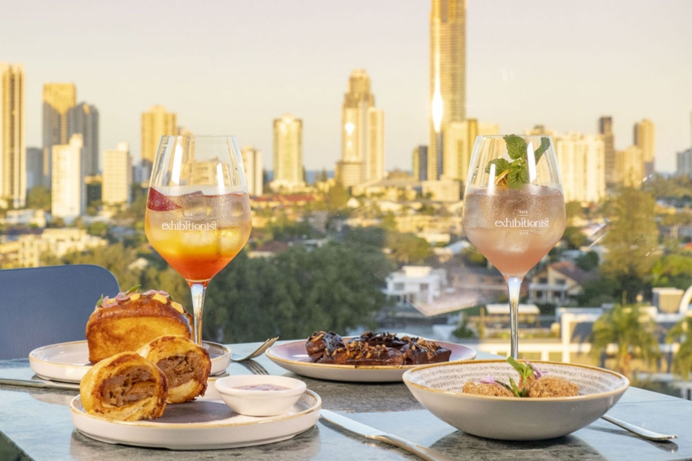 Plates of food and drinks sitting on a table overlooking the Gold Coast