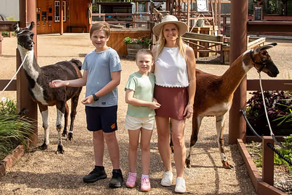 Kids and mother standing with llamas Currumbin Wildlife Sanctuary