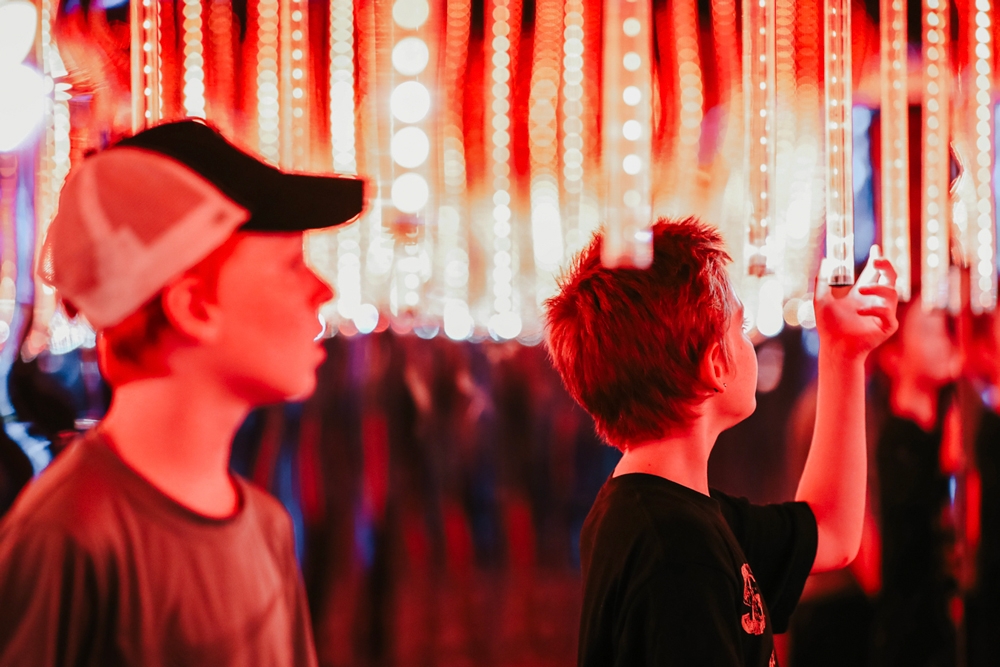 Boys looking at light installation Otherworld Byron Bay
