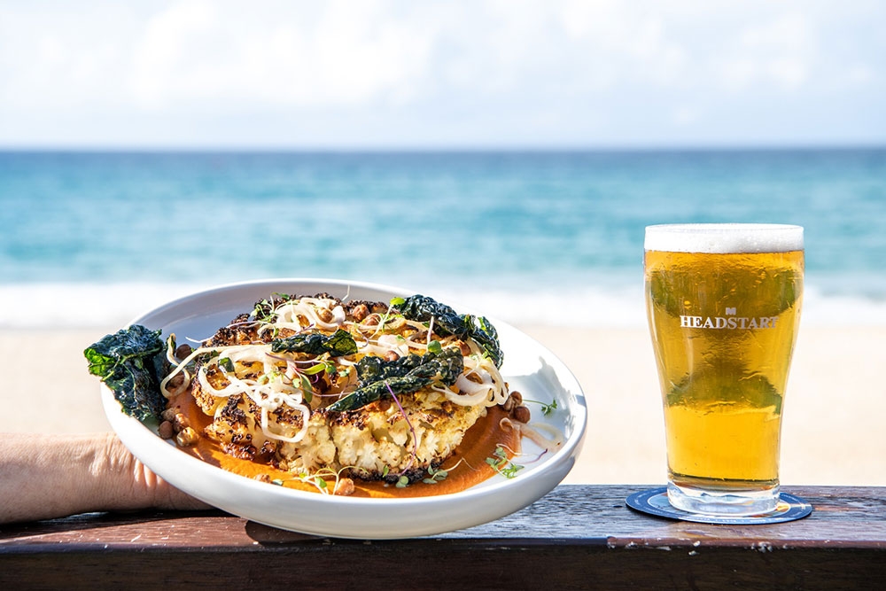 Plate of food and beer on railing 
