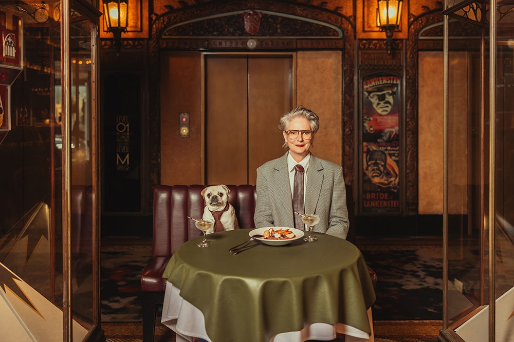 Dog and owner seated at table QY