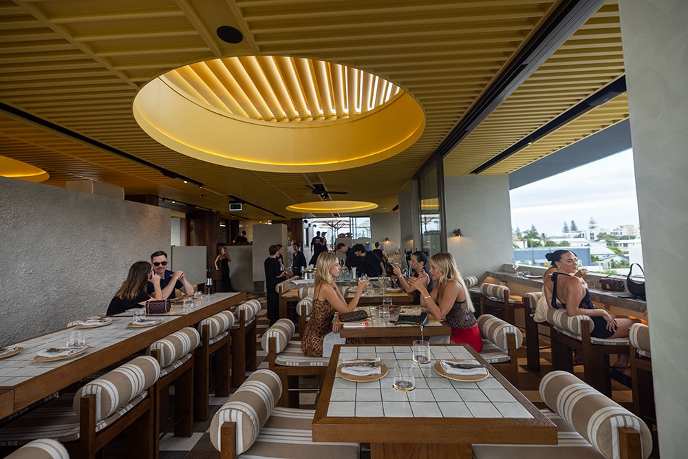 Patrons seated inside under cover area of Sueno Rooftop
