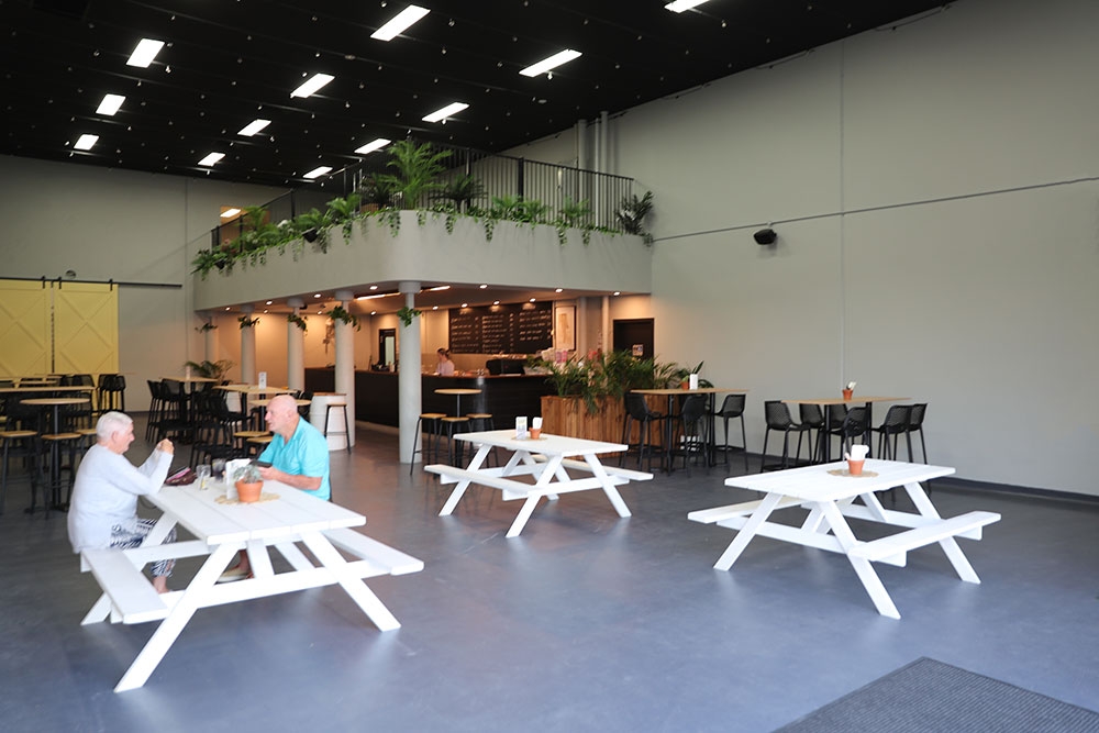 White timber tables inside Sunny Days Distillery