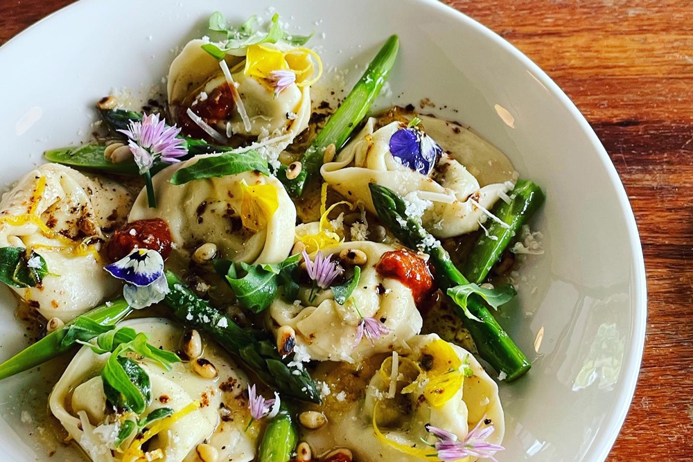 Bowl of ravioli with flower garnishes on top at Trattoria MK III Tamborine Mountain 