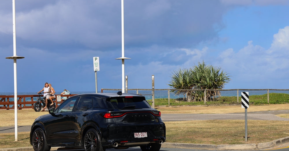 Black Lexus LBX parked in front of a beach 